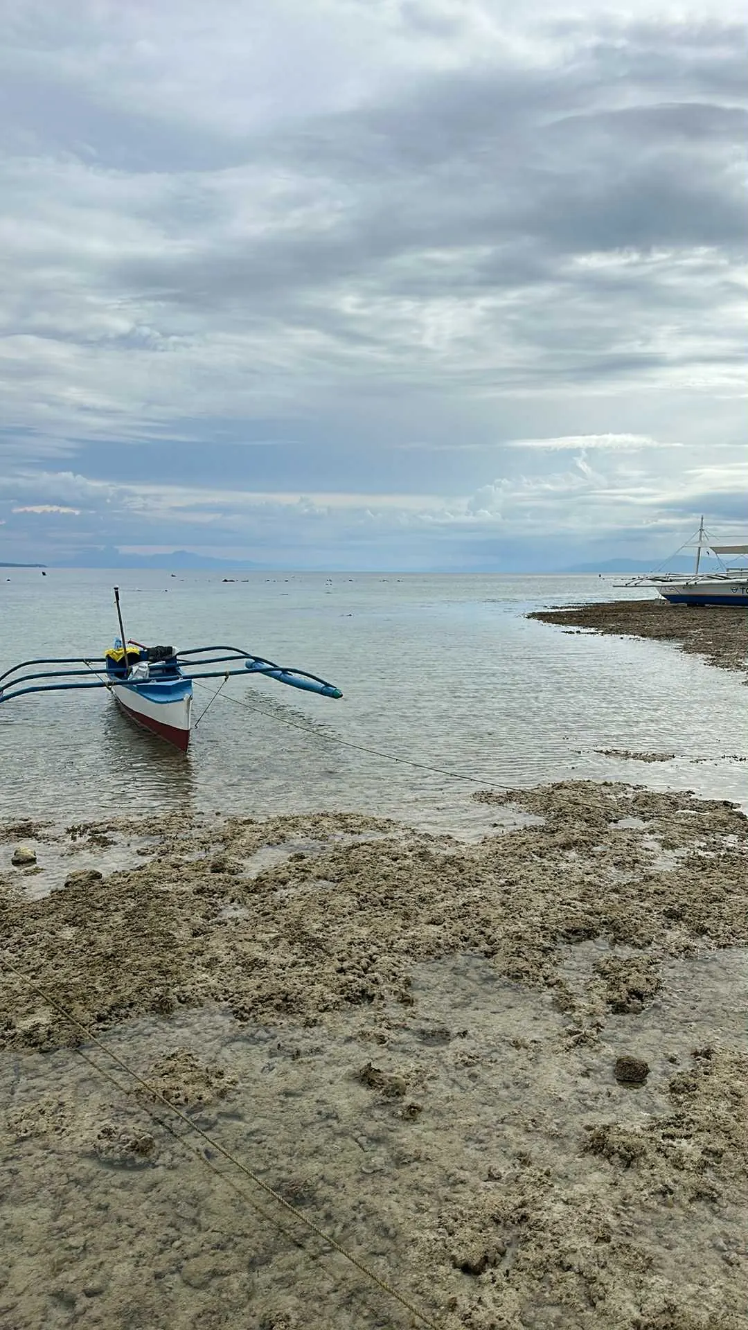 Outrigger boat on the quiet beach two minutes from OIA Suites