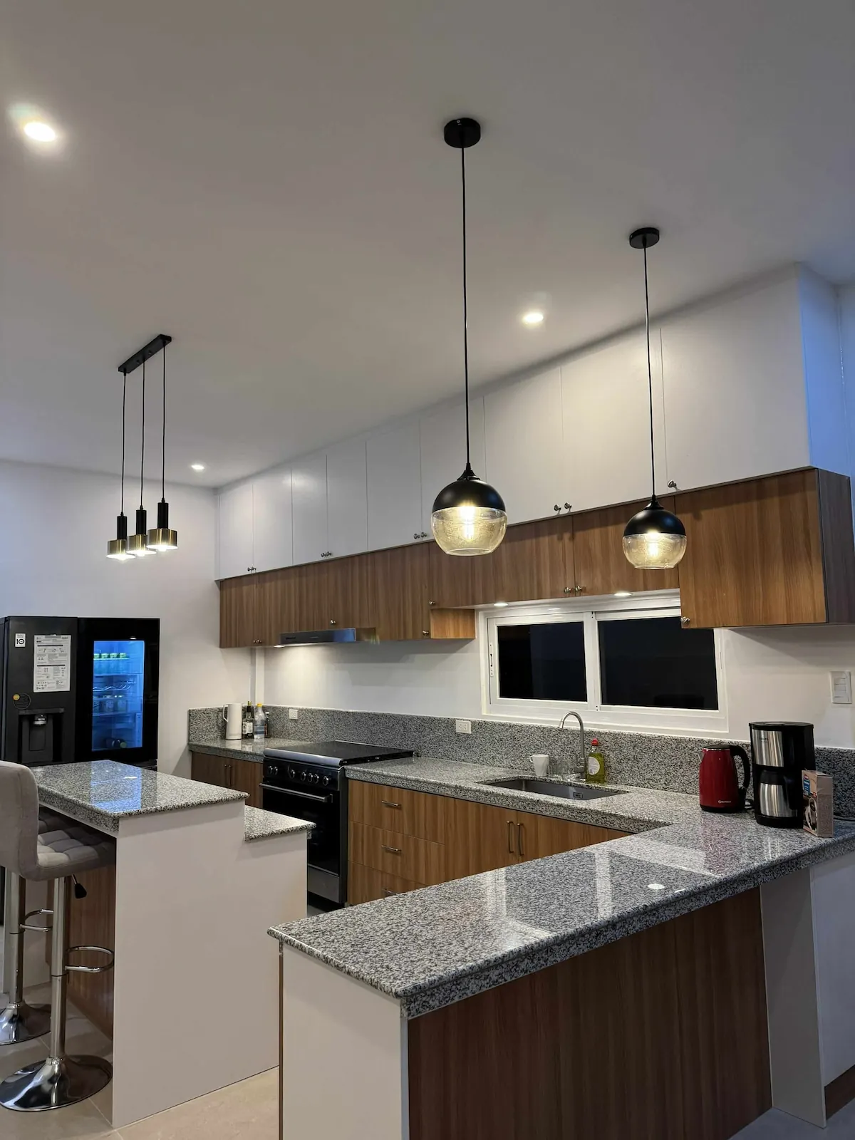 Shared kitchen with granite counters and pendant lights
