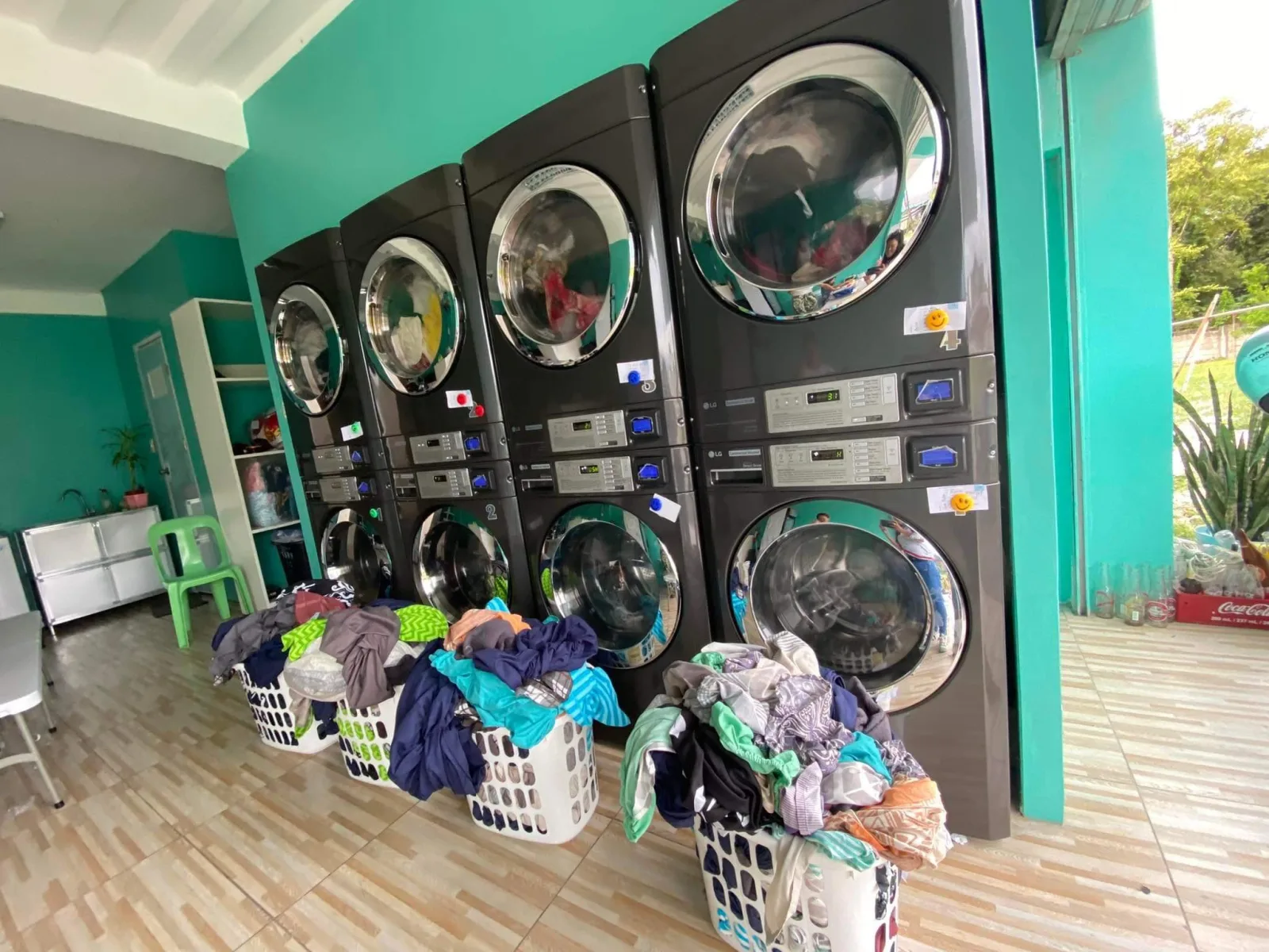 Row of stacked commercial washers and dryers at Laundry Lounge Cebu in Moalboal