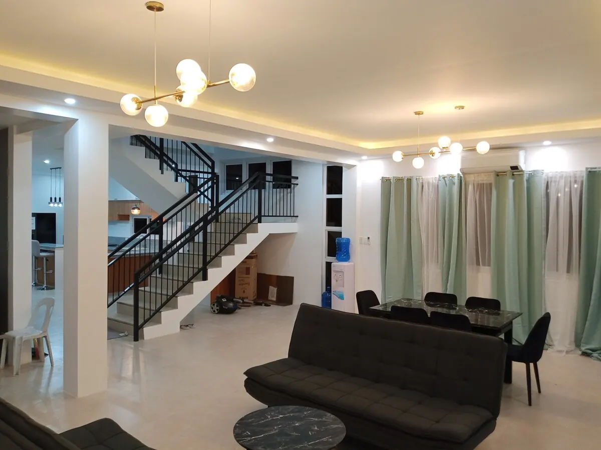 Living room with sofas, dining table and staircase