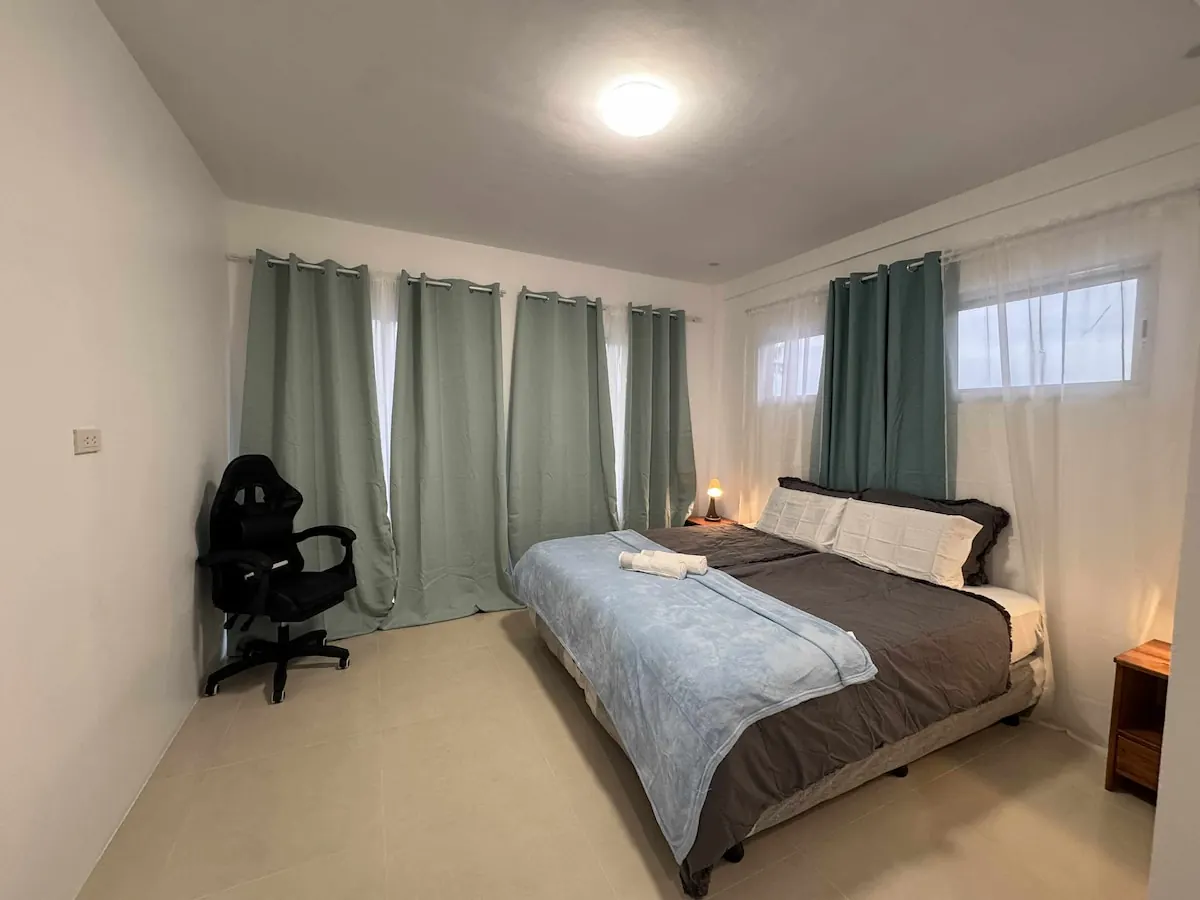 Desk with office chair and king-size bed in a suite at OIA Suites Moalboal